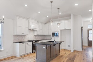 Kitchen featuring custom range hood, appliances wi