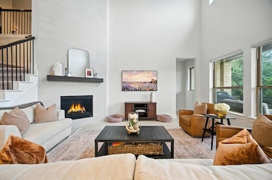 Living room featuring a high ceiling, a fireplace