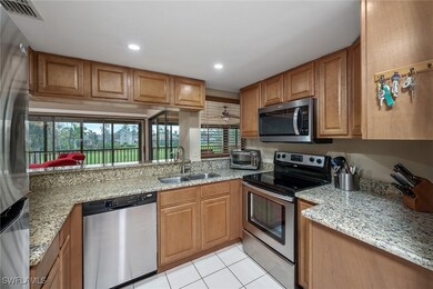 Kitchen with ceiling fan, light stone countertops,