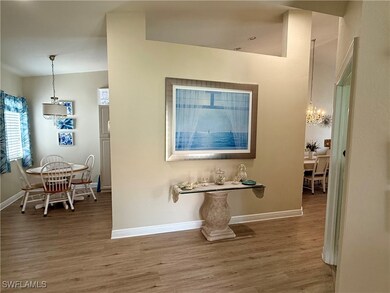 Hall with wood finished floors, baseboards, and a