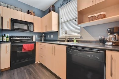Kitchen featuring dark countertops, open shelves,