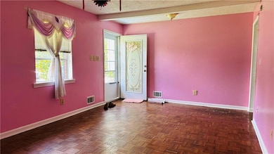 Empty room featuring baseboards and a textured ceiling