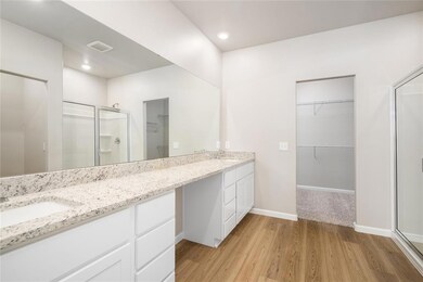 Luxurious Spa-Like Bathroom! Featuring a dual vanity, glass-enclosed shower, and a spacious walk-in closet, this bathroom is designed for both style and convenience.