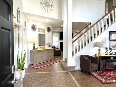 Welcome in! The entry opens to a soaring ceiling and invites you into the formal living room. A downstairs guest bedroom is to the left as well as a bathroom.