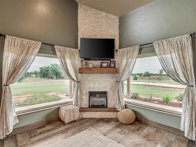 Living room featuring a fireplace, vaulted ceiling, wood finished floors, and plenty of natural light
