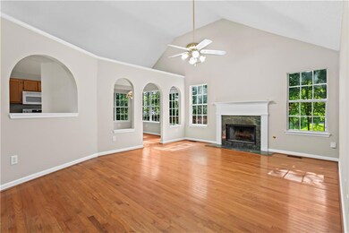 Unfurnished living room with ceiling fan, light wood-style flooring, a fireplace, high vaulted ceiling, and baseboards
