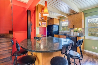 Kitchen featuring black appliances, dark wood fin