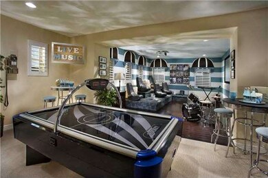 Huge bonus room with game area with walk in storage closet, large home theatre area with platform seating, dark wood floors, shutters.