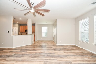 Sunlit, open-concept kitchen with dining nook seamlessly flows into the inviting living area.