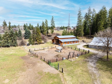 View of community featuring an outdoor structure, an exterior structure, an outbuilding, a yard, and fence