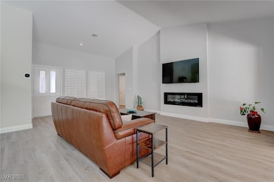 Living room with light wood-type flooring, a glass