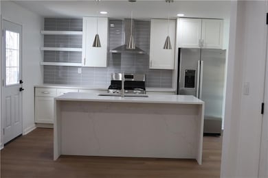 Kitchen with an island with sink, appliances with 