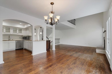 Kitchen featuring white cabinetry, open floor pla