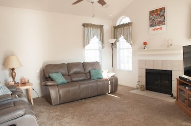 Carpeted living room featuring a tile fireplace, l