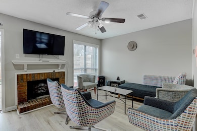 Living area with visible vents, a fireplace, wood 