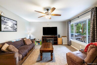 Living area featuring carpet flooring and a ceiling fan
