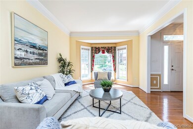 Living room with ornamental molding and wood-type