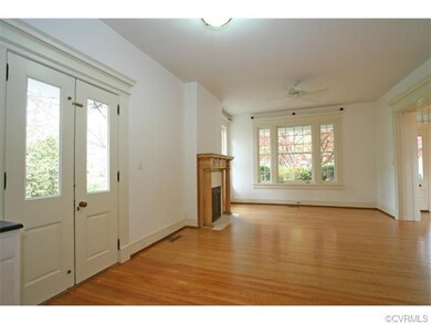 Family room has a fireplace with natural wood mantel and fluted columns and French doors that open to the side patio.