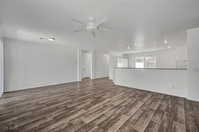 Unfurnished living room featuring ceiling fan, dar