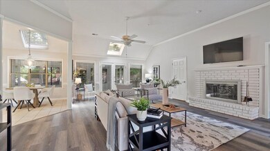 Living room featuring lofted ceiling with skylight