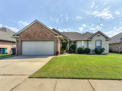 View of front of home featuring driveway, a front yard, an attached garage, stone siding, and roof with shingles