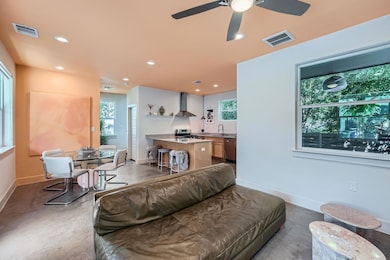 Living room with ceiling fan, finished concrete f