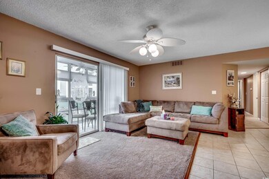 Living room with ceiling fan, light tile patterned