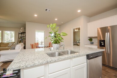 Spacious granite island countertop with double sinks.