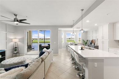 Living area featuring light tile patterned flooring, recessed lighting, a water view, and ceiling fan