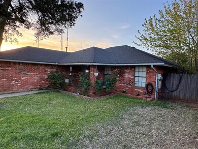 Back of house with brick siding, fence, a shingled