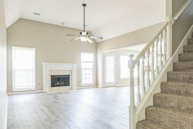 Unfurnished living room with a ceiling fan, a fire