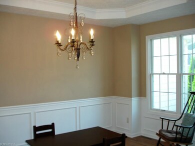 The Dining room features a tray ceiling, wood floo