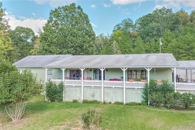 Rear view of property featuring a porch and a yard