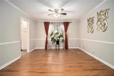 Empty room with wood finished floors, ornamental molding, a textured ceiling, and a ceiling fan