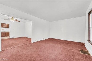Carpeted empty room featuring ceiling fan, a healthy amount of sunlight, and sink
