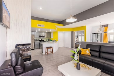 Living area featuring light wood-type flooring and a chandelier