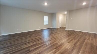 Empty room with dark wood-style floors and recessed lighting