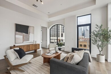 Living room with visible vents, baseboards, wood finished floors, and a raised ceiling