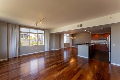 Kitchen featuring open floor plan, dark countertops, dark wood-style flooring, and a chandelier