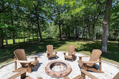 View of patio / terrace featuring an outdoor fire pit and view of wooded area