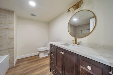 Bathroom featuring vanity, light wood-type flooring, a bathtub, and a shower
