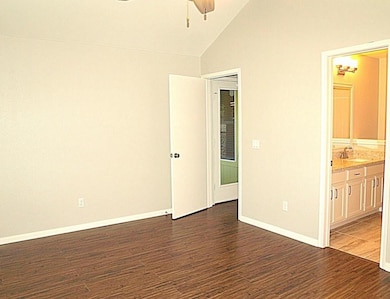 Empty room featuring a ceiling fan, vaulted ceili