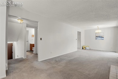 new paint in carpeted living room with a chandelier