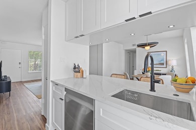 Kitchen with light stone countertops, white cabin
