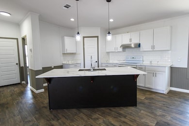 Kitchen featuring crown molding, light stone coun