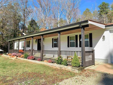 Ranch-style house with covered porch and a front y