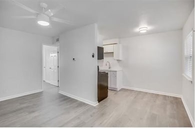 Kitchen featuring white cabinetry, sink, ceiling f