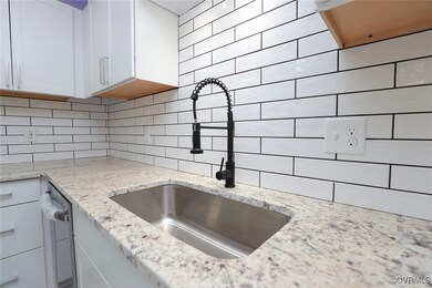 Kitchen featuring backsplash, white cabinetry, a s