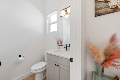 Half bathroom with vanity and light wood finished floors