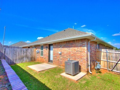Rear view of property with a fenced backyard, brick siding, a patio, and a shingled roof